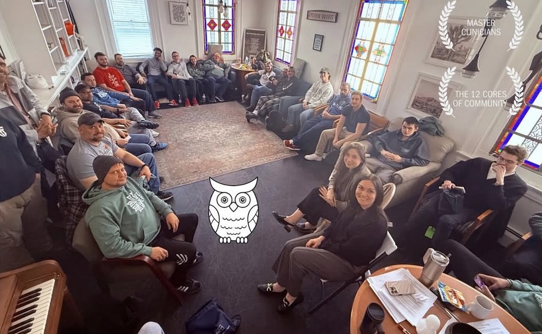 A group gathered in a bright room with stained-glass windows