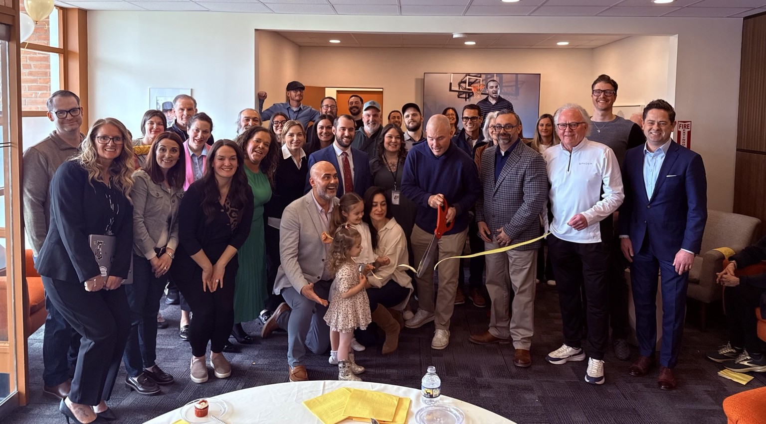 An indoor ribbon-cutting celebration with families and community members